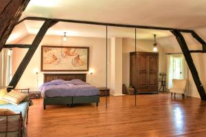 a bedroom with a bed and a painting on the wall at Le Prieuré La Ferme in Souillac