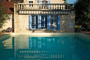 a house with a swimming pool in front of a building at Le Prieuré La Ferme in Souillac +9 photos