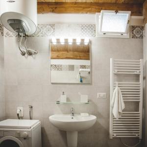 een witte badkamer met een wastafel en een spiegel bij La Casa Dei Nonni in Irsina