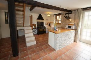 a kitchen with a counter and a stove top oven at Le Prieuré La Ferme in Souillac