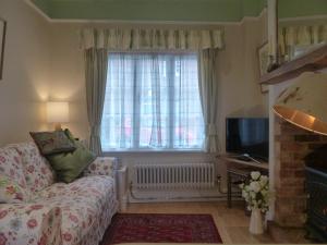 a living room with a couch and a window at The Little House in Devizes