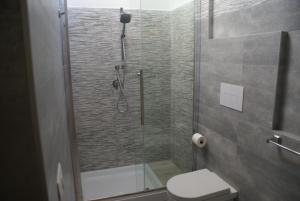 a bathroom with a glass shower with a toilet at casa mariolu 2 in Cala Gonone