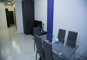 ein Esszimmer mit einem Glastisch und Stühlen in der Unterkunft "Royal" apartment #01 in Yerevan