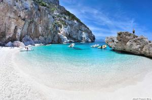 a group of people in the water at a beach at casa mariolu 2 in Cala Gonone