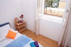 a room with a bed and an open window at Tania Apartment in Prizba