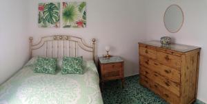 Schlafzimmer mit einem Bett, einer Kommode und einem Spiegel in der Unterkunft El Balcón de Rosita in Morche