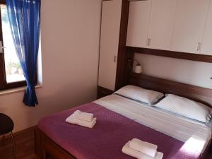a bedroom with a bed with two towels on it at Holiday Home Cvitka in Vis