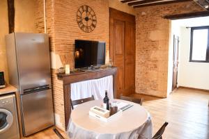 a kitchen with a table with a refrigerator and a television at Habitation Saint-Clar Vieille Ville in Bergerac