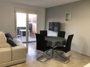 a living room with a table and chairs and a couch at Apartamentos Corcubión in Corcubión