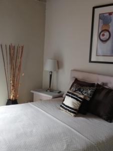 a bedroom with a bed with a pillow and a lamp at PGS -Surf, Work, Relax in Christ Church
