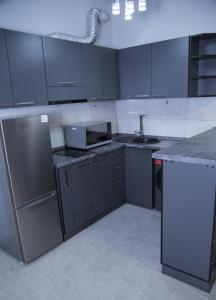 een keuken met grijze kasten, een wastafel en een koelkast bij "Royal" APARTMENT #2 in Jerevan