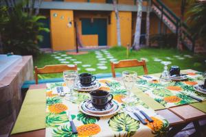 a table with plates and glasses on top of it at Pousada Cantinho do PÊ Guarujá in Guarujá