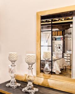 un espejo en una mesa junto a dos cristales en Lofts amantes de Toledo- LOFT ALCAZAR, en Toledo
