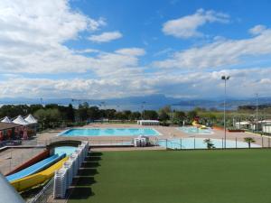 una grande piscina con un prato verde accanto ad essa di RUSTICO PARK DELLE ROSE - Regarda Travel a Lazise