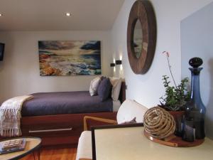 a bedroom with a bed and a table and a mirror at Salt Box Hideaway in Strahan