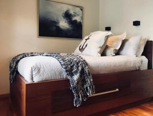 a bed with a white bedspread and pillows at Salt Box Hideaway in Strahan