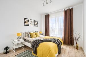 um quarto com uma cama amarela e uma janela em M&R Apartament Airport&Business Premium Komputerowa - underground garage - free WiFi - Netflix - self check-in - 5 min from Chopin Airport em Varósvia