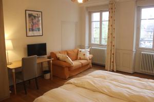 a living room with a couch and a desk with a television at lesboisjolis in Colmar