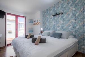 a bedroom with a large white bed with blue walls at B&B do Paço in Lagos