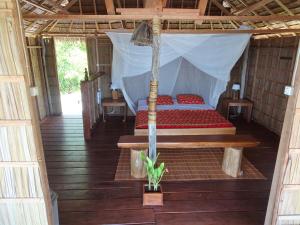 ein Schlafzimmer mit einem Bett in einem Zelt in der Unterkunft Methos Homestay - Raja Ampat in Yennanas Besir