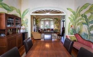 a living room with a painting of palm trees on the wall at Auld Sweet Olive Bed and Breakfast in New Orleans