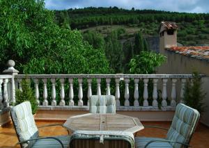 a wooden table and chairs on a balcony at La Noguera in Palomera