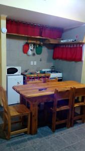 uma cozinha com uma mesa de madeira e cadeiras em Departamentos de Alquiler Turistico: Familia Eguren em San Carlos de Bariloche