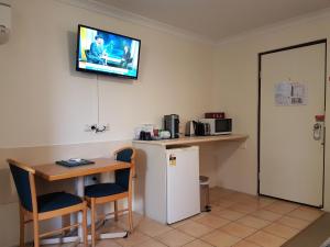 
a kitchen with a tv and a refrigerator at Rockhampton Palms Motor Inn in Rockhampton
