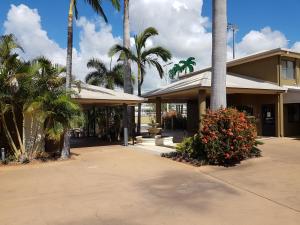 budynek z palmami i dziedzińcem w obiekcie Rockhampton Palms Motor Inn w mieście Rockhampton