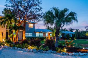a house with two palm trees and lights in front at Seascape Resort & Marina in Marathon