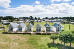 eine Reihe von Häusern mit grünem Dach in der Unterkunft Foxton Beach Holiday Park in Foxton Beach