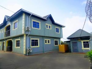 a blue house with a lot of windows at O2 Apartments in Ibadan