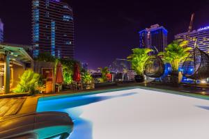 ein Pool mit einer Skyline der Stadt in der Nacht in der Unterkunft Roseland Centa Hotel & Spa in Ho-Chi-Minh-Stadt