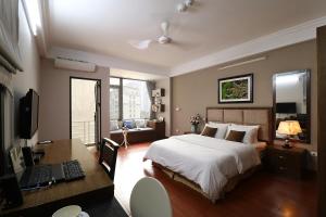 a bedroom with a bed and a desk with a computer at ISTAY Hotel Apartment 1 in Hanoi