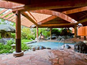 那須的住宿－那須陽光谷酒店，一个带游泳池的木制凉棚下的游泳池