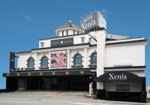 un edificio blanco con un cartel encima en Xenia Amagasaki, en Amagasaki