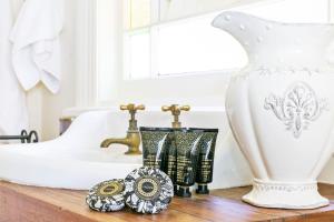 eine Badezimmertheke mit einer weißen Vase und einem Waschbecken in der Unterkunft Gowan Brae Cottage in Katoomba
