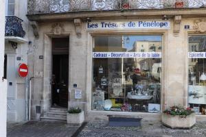 una tienda frente a un edificio con un cartel. en Residence du marche, en Jonzac