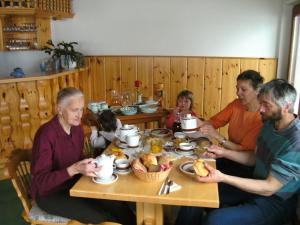 grupa ludzi siedzących przy stole jedzących jedzenie w obiekcie Ferienhof Rotbuchner w mieście Vorderstoder