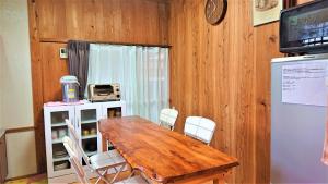 屋久島にあるCottage Yakusugi Houseの木製のテーブルと白い椅子のあるダイニングルーム