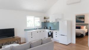 a kitchen with a couch and a living room with a bed at Bangalow Guesthouse in Bangalow