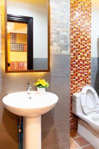 uma casa de banho com um lavatório, um WC e um espelho. em Lilliput Riverside Bangkachao em Samutprakarn