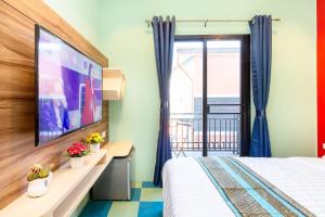 um quarto de hotel com uma cama e uma televisão em Lilliput Riverside Bangkachao em Samutprakarn