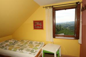 a small bedroom with a bed and a window at Vineyard Cottage Vrbek in Roginska Gorca