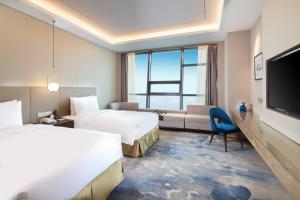 Postel nebo postele na pokoji v ubytování Auto City Ruili Hotel + 37 fotografií