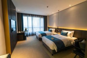 Postel nebo postele na pokoji v ubytování Hangzhou Cosy Park Hotel(Liangzhu)
