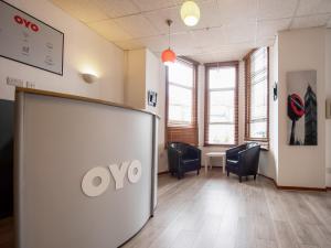 una sala de espera con sillas y una puerta abierta en OYO Arinza Hotel, London Ilford, en Ilford