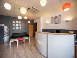 an office with a counter and a table and a bench at Arinza Hotel, London Ilford in Ilford
