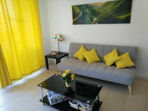 uma sala de estar com um sofá com almofadas amarelas em Apartamento Green Park Relax em San Miguel de Abona