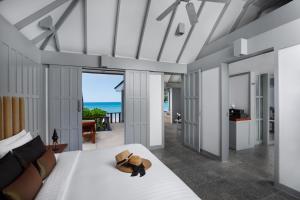 a bedroom with a bed and a view of the ocean at The Surin Phuket in Surin Beach +37 photos